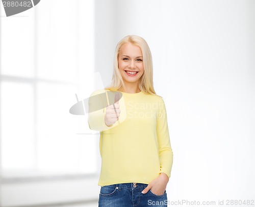 Image of smiling girl in casual clothes showing thumbs up