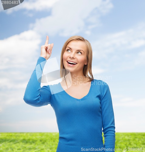 Image of smiling woman pointing her finger up