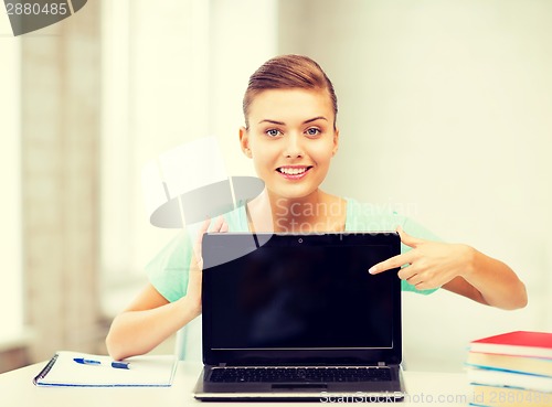 Image of smiling student girl with laptop at school