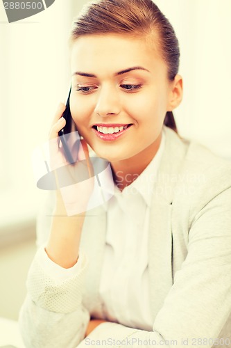 Image of businesswoman with smartphone in office