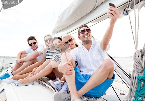 Image of smiling friends sitting on yacht deck