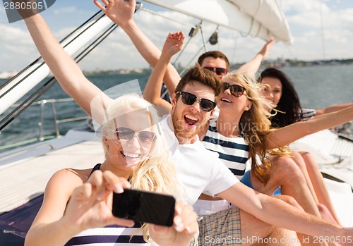 Image of smiling friends sitting on yacht deck