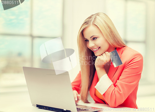 Image of happy teenage girl with laptop and credit card