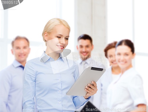 Image of smiling woman looking at tablet pc computer