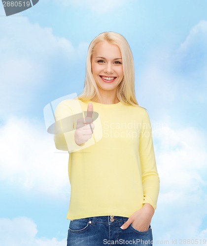 Image of smiling girl in casual clothes showing thumbs up