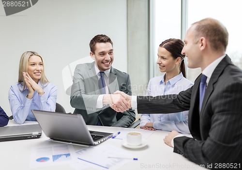 Image of two businessman shaking hands in office