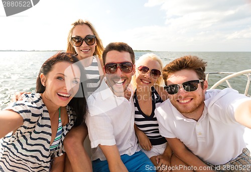 Image of smiling friends sitting on yacht deck