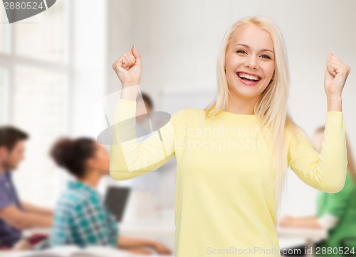Image of laughing young woman with hands up