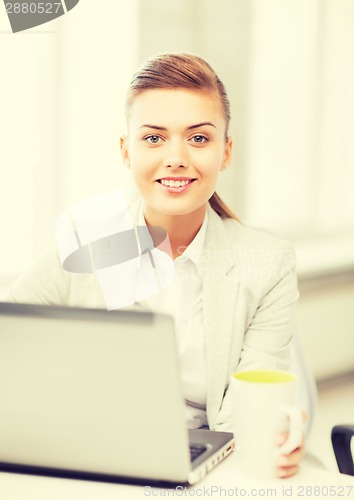 Image of businesswoman with laptop in office