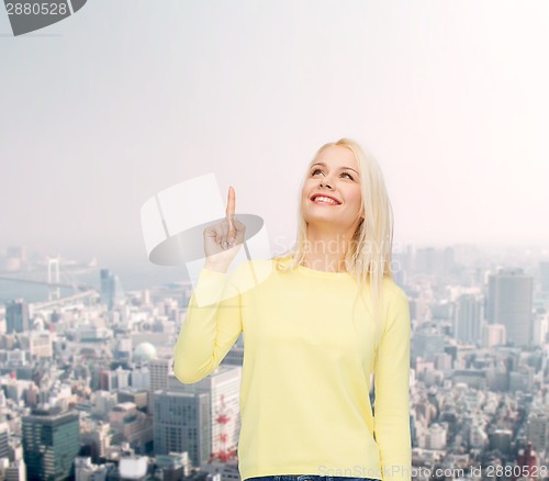 Image of smiling woman pointing her finger up