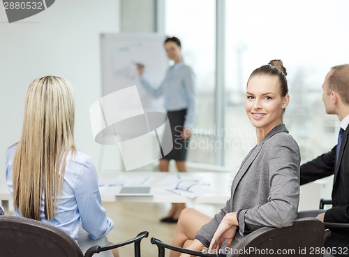 Image of businesswoman with team showing in office