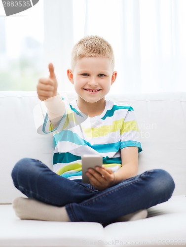 Image of smiling boy with smartphone showing thumbs up