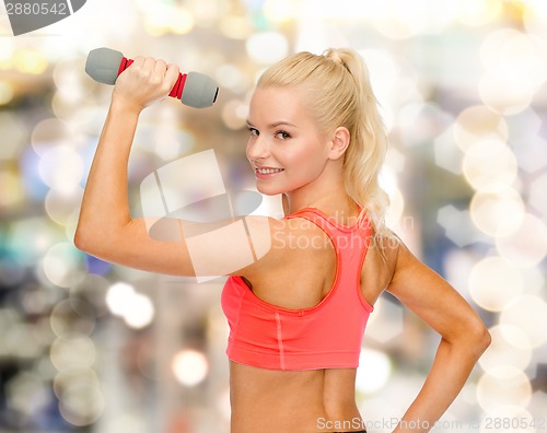 Image of young sporty woman with light dumbbell