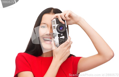 Image of smiling woman taking picture with digital camera