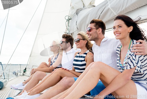 Image of smiling friends sitting on yacht deck