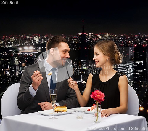Image of smiling couple eating dessert at restaurant