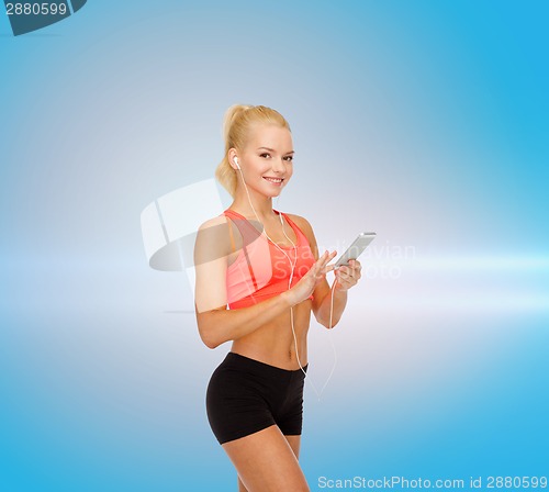 Image of smiling sporty woman with smartphone and earphones