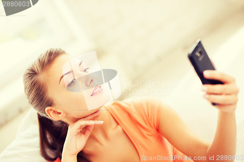 Image of woman making self portrait with smartphone