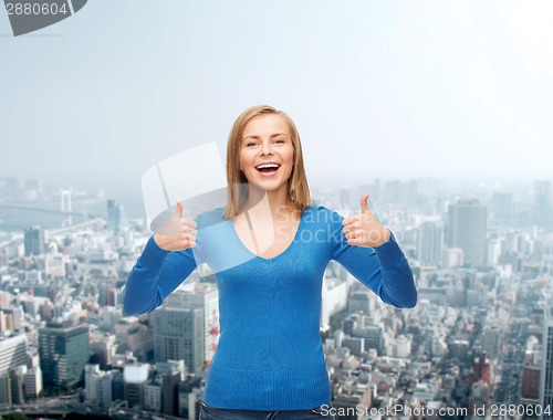 Image of smiling girl in casual clothes showing thumbs up