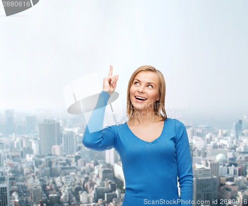 Image of smiling woman pointing her finger up