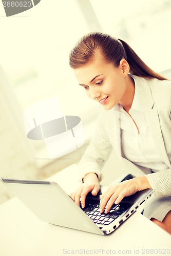 Image of businesswoman with laptop in office
