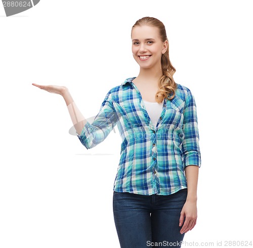 Image of smiling young woman holding something on hand