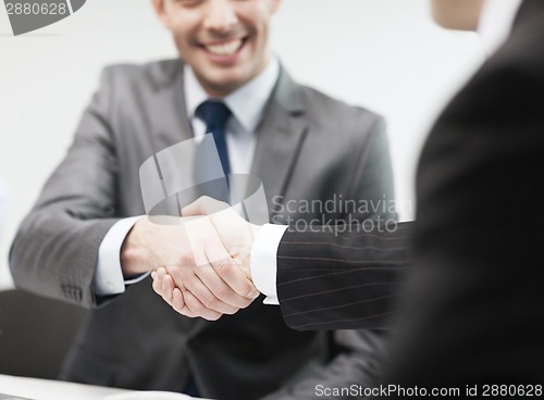 Image of two businessmen shaking hands in office