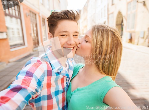 Image of smiling couple with smartphone in city