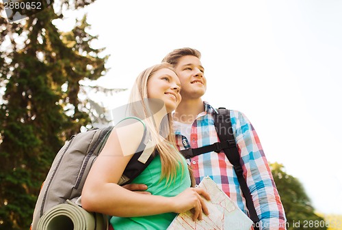 Image of smiling couple with map and backpack in nature