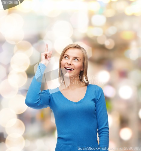 Image of smiling woman pointing her finger up