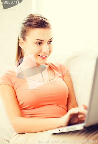 Image of happy woman using laptop at home