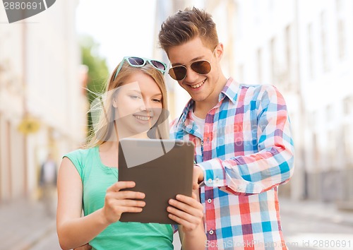 Image of smiling couple with tablet pc in city