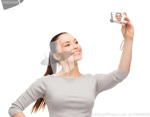 Image of smiling asian woman with digital camera