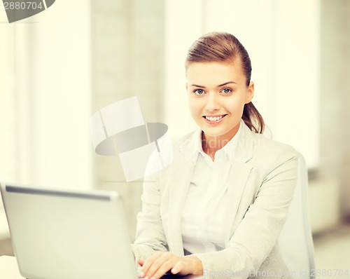 Image of businesswoman with laptop in office