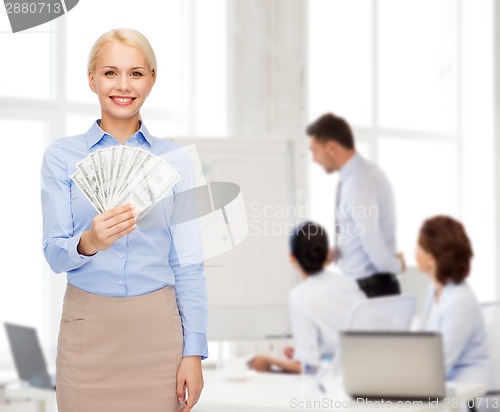 Image of young businesswoman with dollar cash money