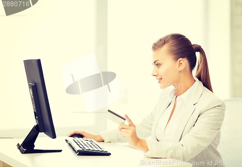 Image of businesswoman with computer using credit card