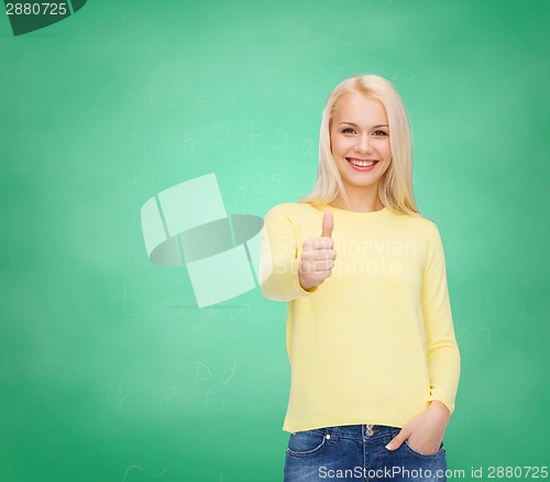 Image of smiling girl in casual clothes showing thumbs up