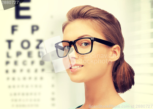 Image of woman in eyeglasses with eye chart