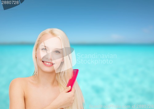 Image of smiling woman with hair brush