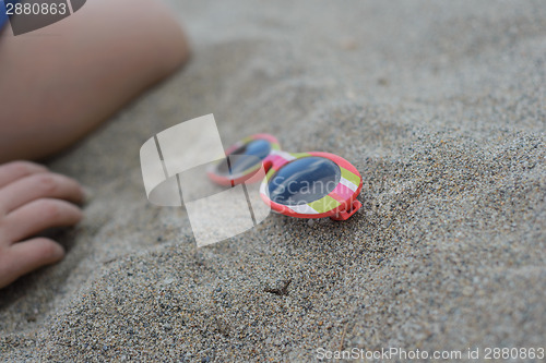 Image of Striped sunglasses in the sand