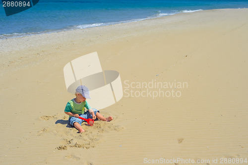 Image of Little boy playing with sand