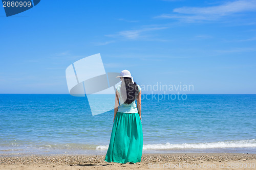 Image of Brunette female standing alone on the beach