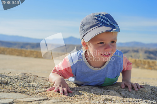 Image of Little boy laying down on the rock