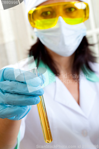 Image of doctor shows a test tube of yellow solution