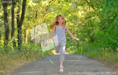 Image of little girl jumps over rope