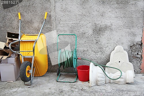 Image of Wheelbarrow, hose and cartons