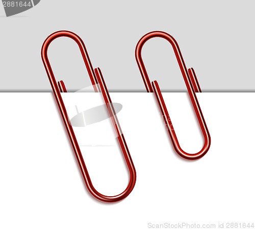 Image of Red metal paperclip and paper