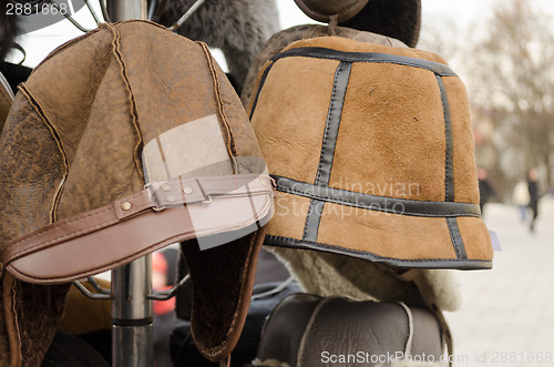 Image of male brown decorated winter hats on rack  