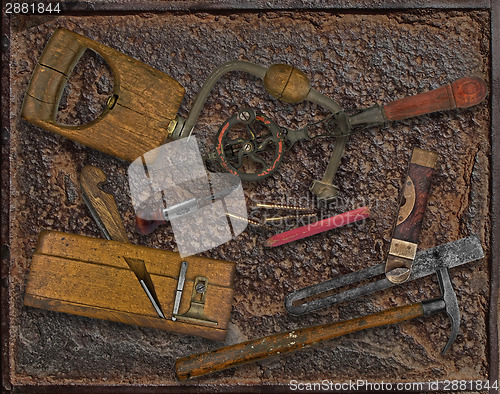 Image of vintage woodworking tools over rusty plate