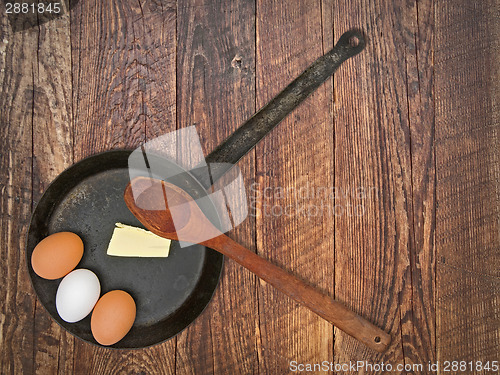 Image of vintage set for frying eggs over wooden table